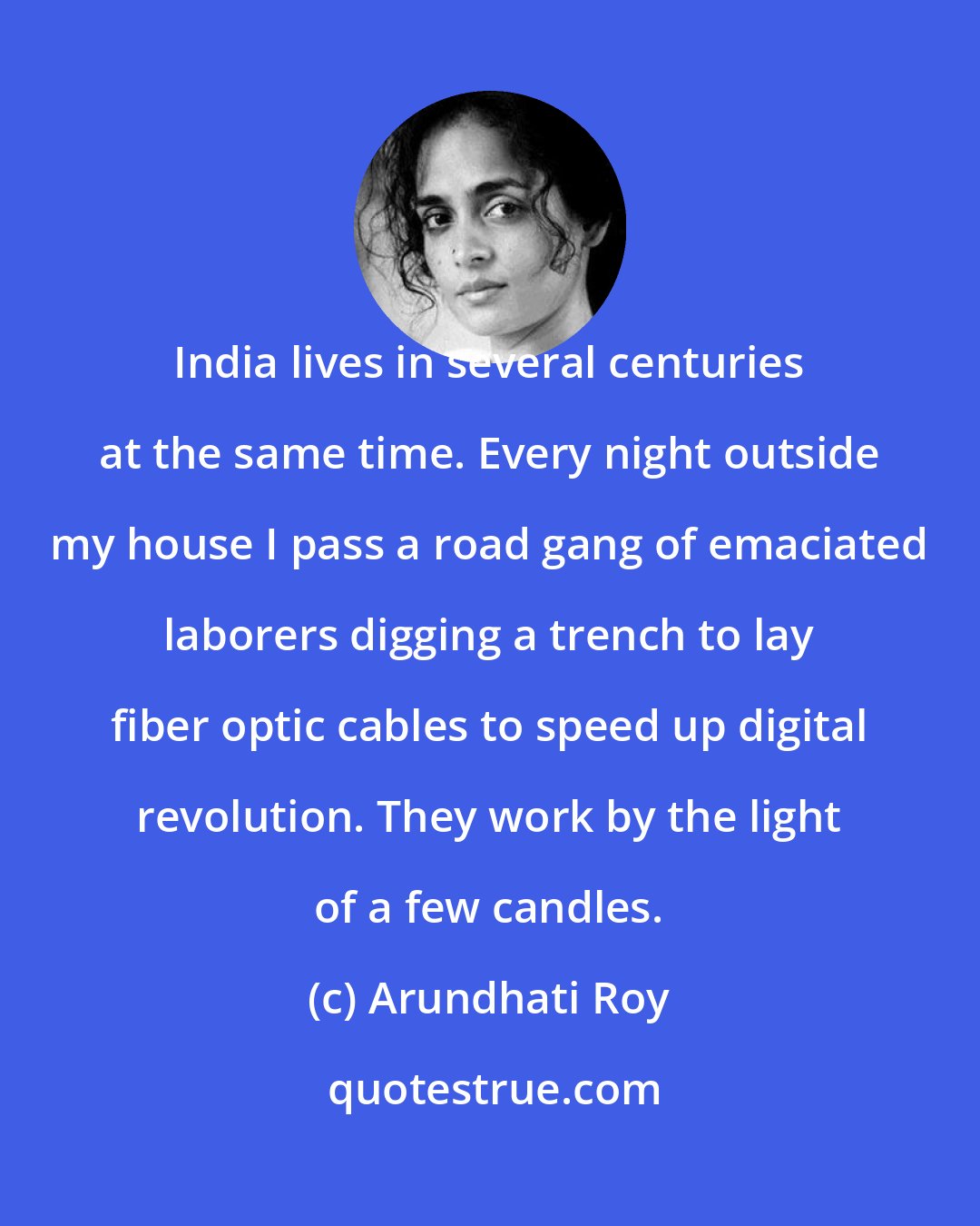 Arundhati Roy: India lives in several centuries at the same time. Every night outside my house I pass a road gang of emaciated laborers digging a trench to lay fiber optic cables to speed up digital revolution. They work by the light of a few candles.