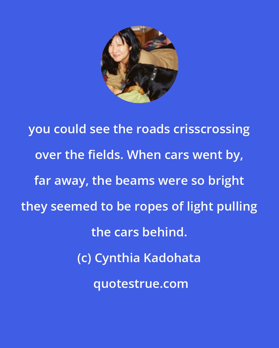 Cynthia Kadohata: you could see the roads crisscrossing over the fields. When cars went by, far away, the beams were so bright they seemed to be ropes of light pulling the cars behind.